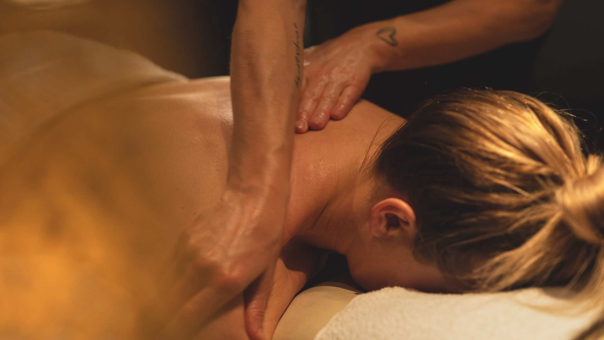 Person får avkopplande massage på spa med varm belysning