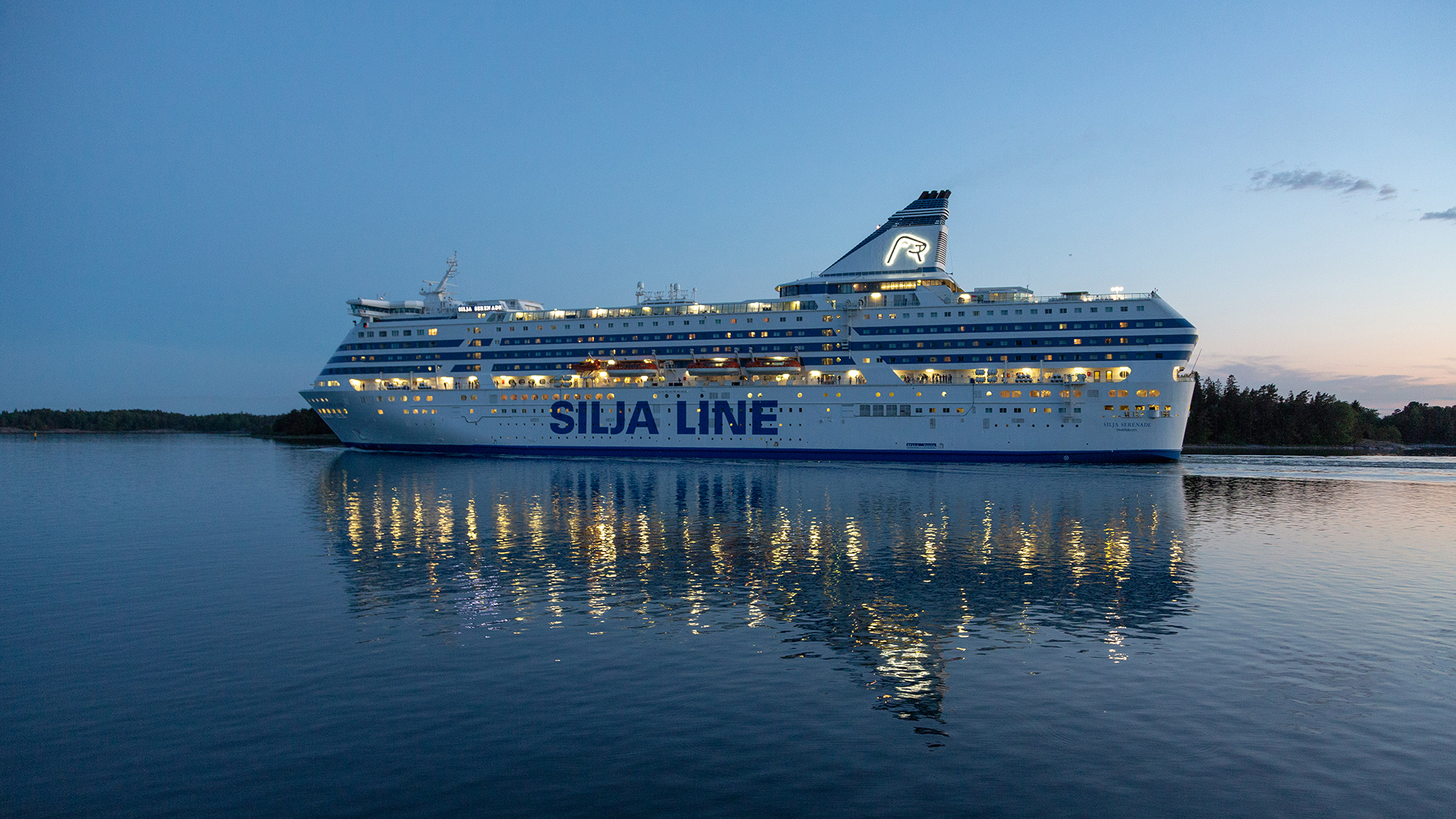 Silja Line-Fähre im Sonnenuntergang auf stillem Wasser, umgeben von Schärengartenlandschaft