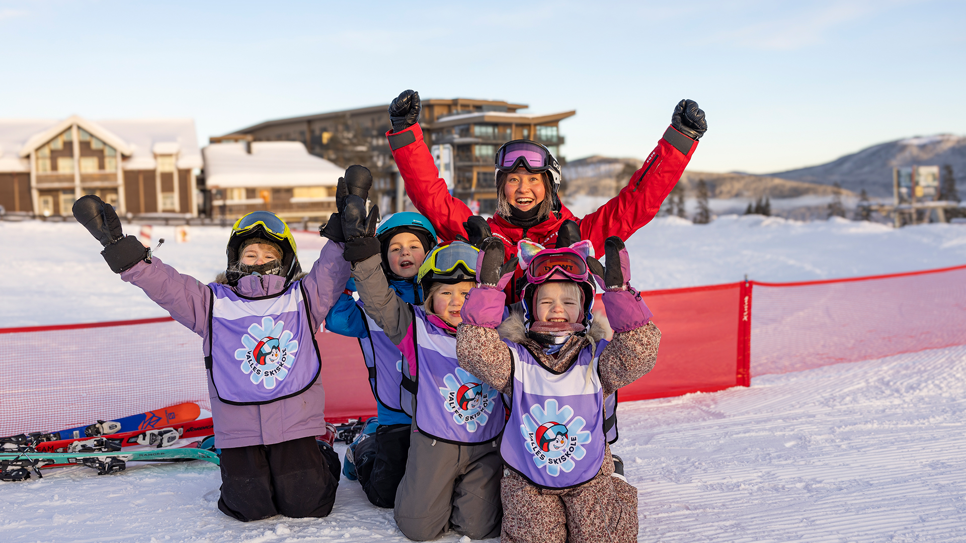 Barn glada och entusiastiska på skidlekplats med instruktör i snöig alpin miljö, redo för skidskola