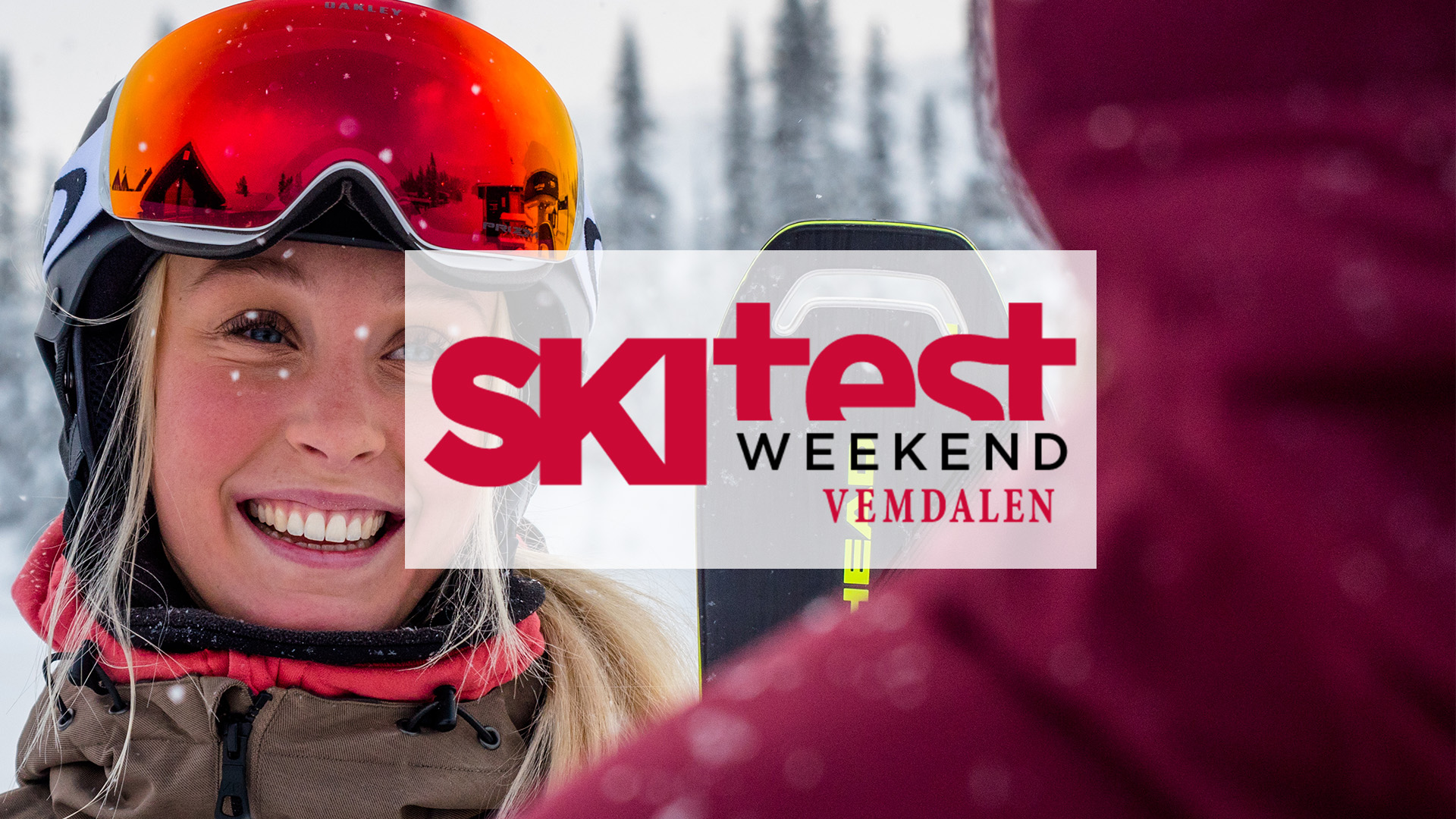 Kvinna i skidutrustning leende under Skitest Weekend i Vemdalen, med snöiga träd i bakgrunden