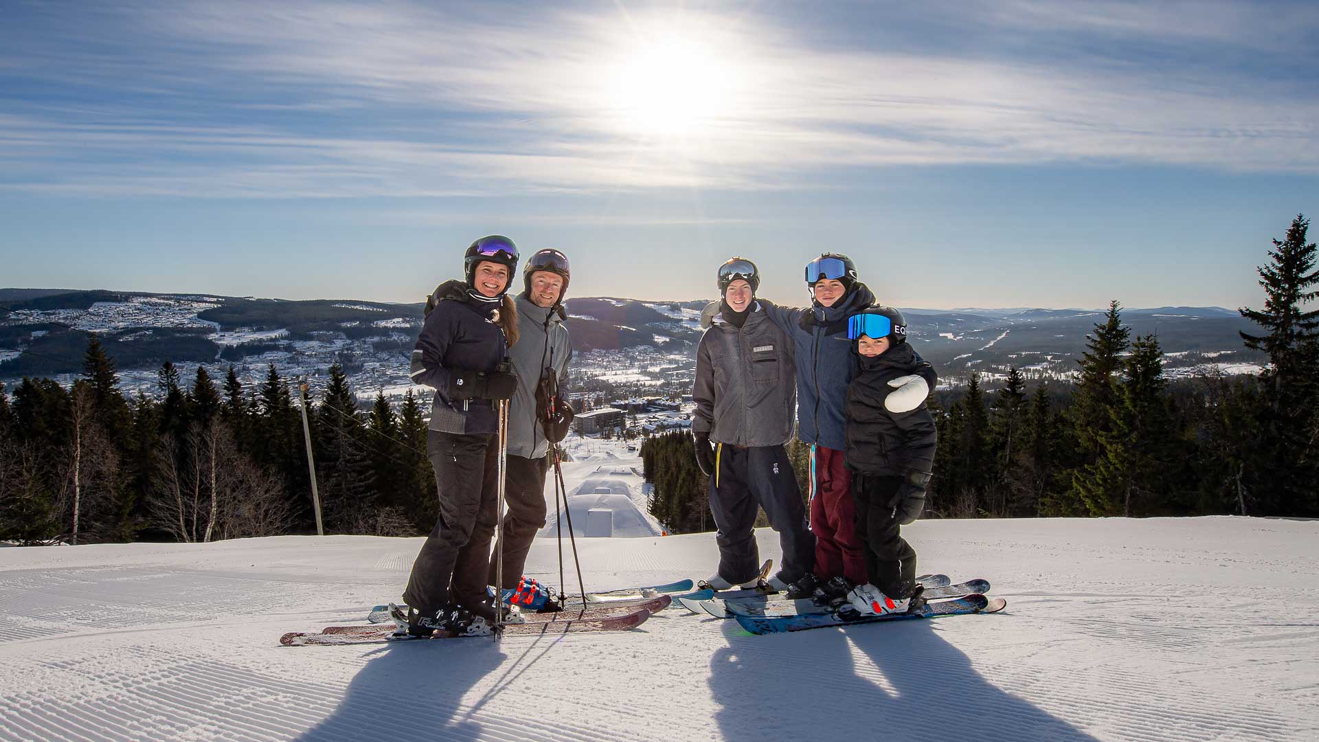 A group of happy skiers on a sunny day in the mountains, surrounded by snow-covered trees and a beautiful mountain view