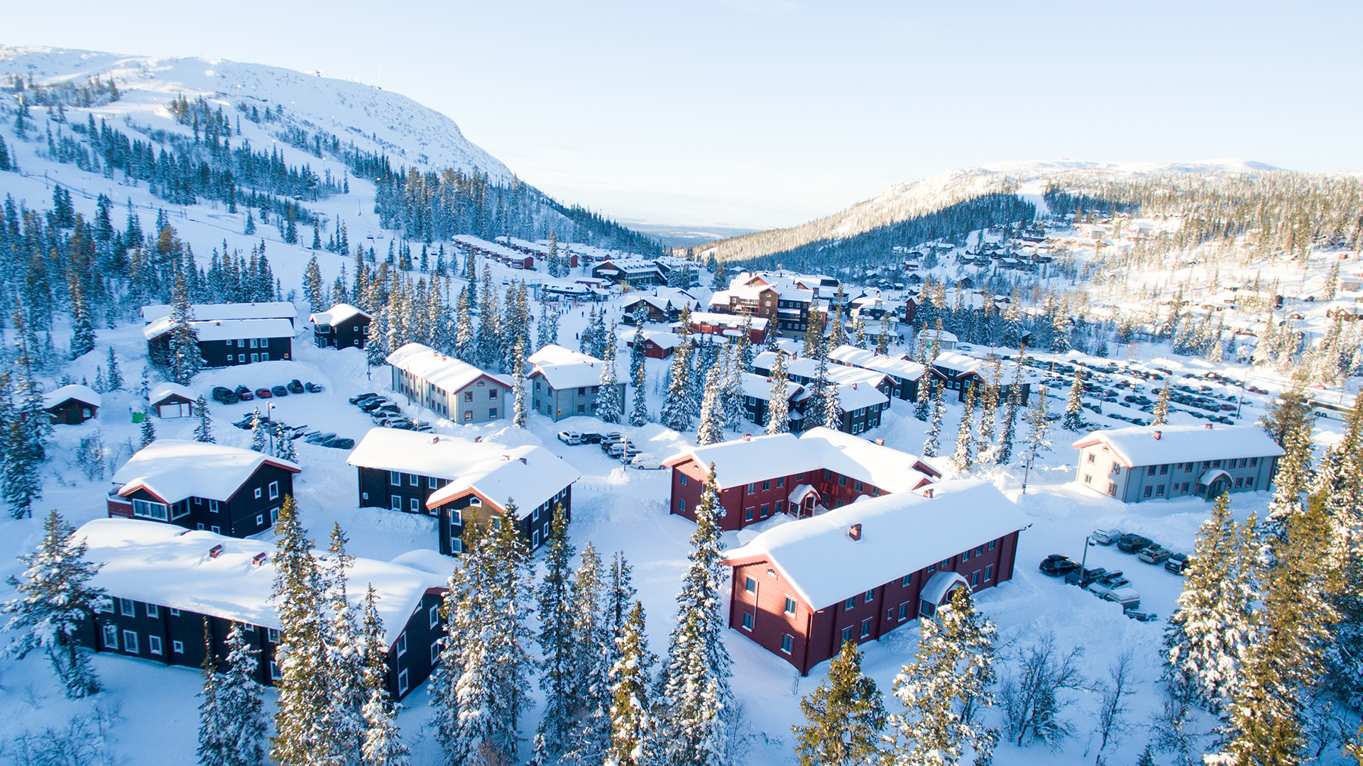 Vinterlandskap i fjällen med snötäckta stugor och skogar, perfekt för vintersport och naturaktiviteter i Vemdalsskalet