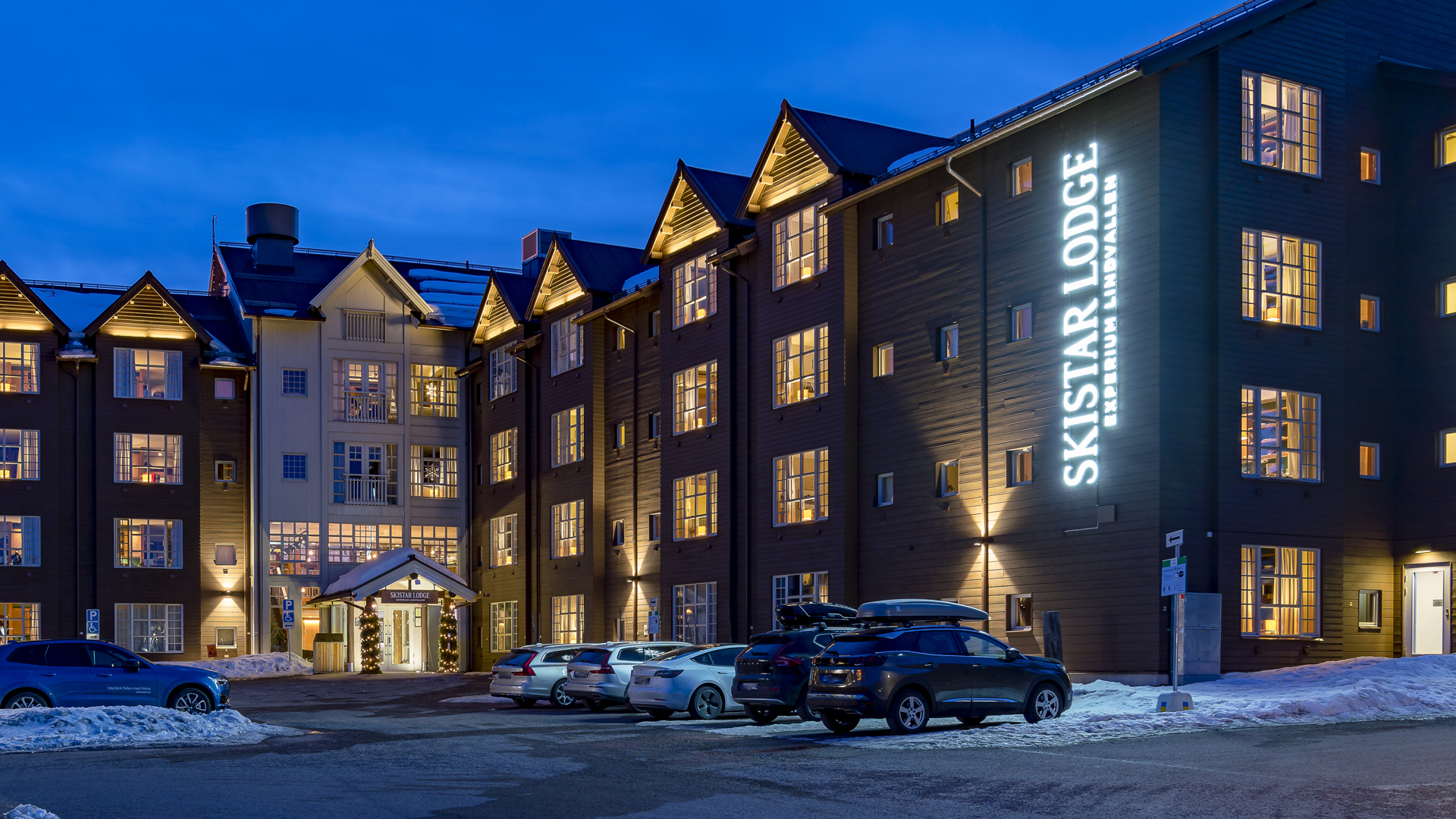 Fjällhotell Skistar Lodge i Sälen vid skymning med upplysta fönster och parkerade bilar i förgrunden