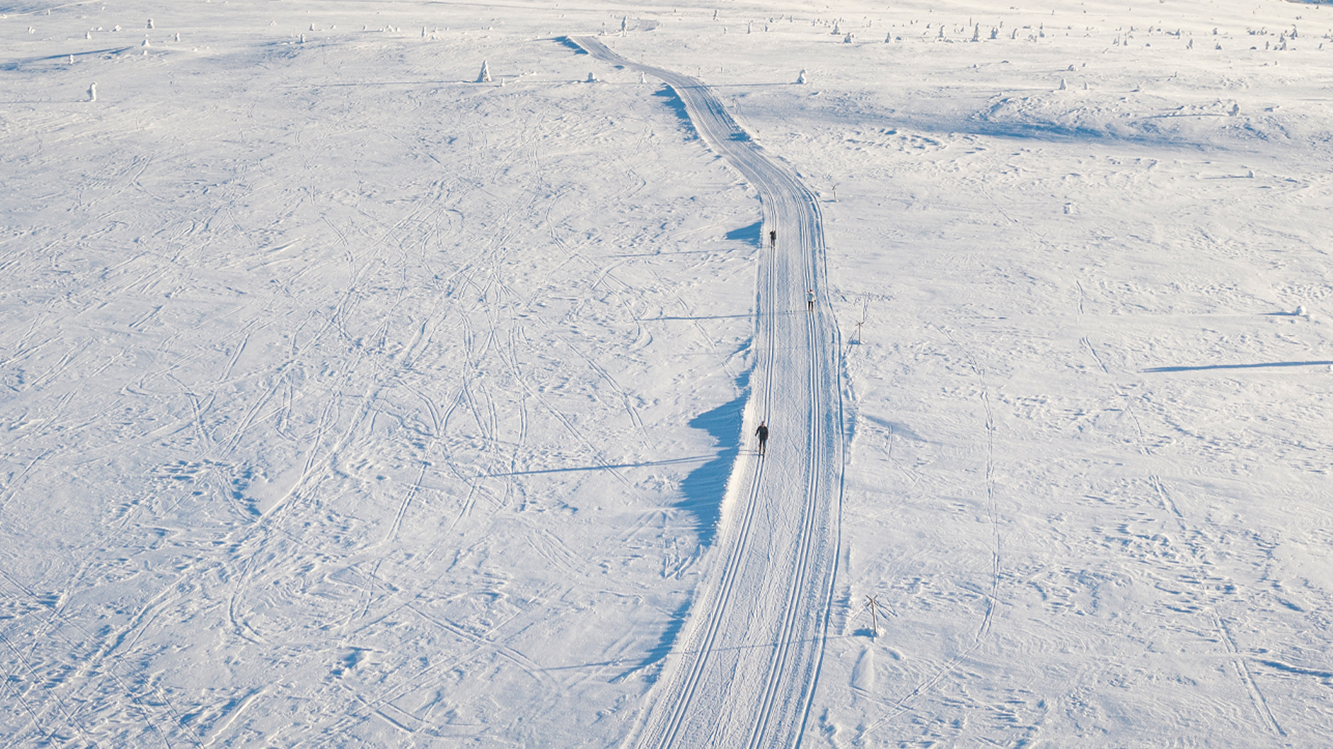 Längdskidåkare på snötäckt fjälllandskap en solig dag
