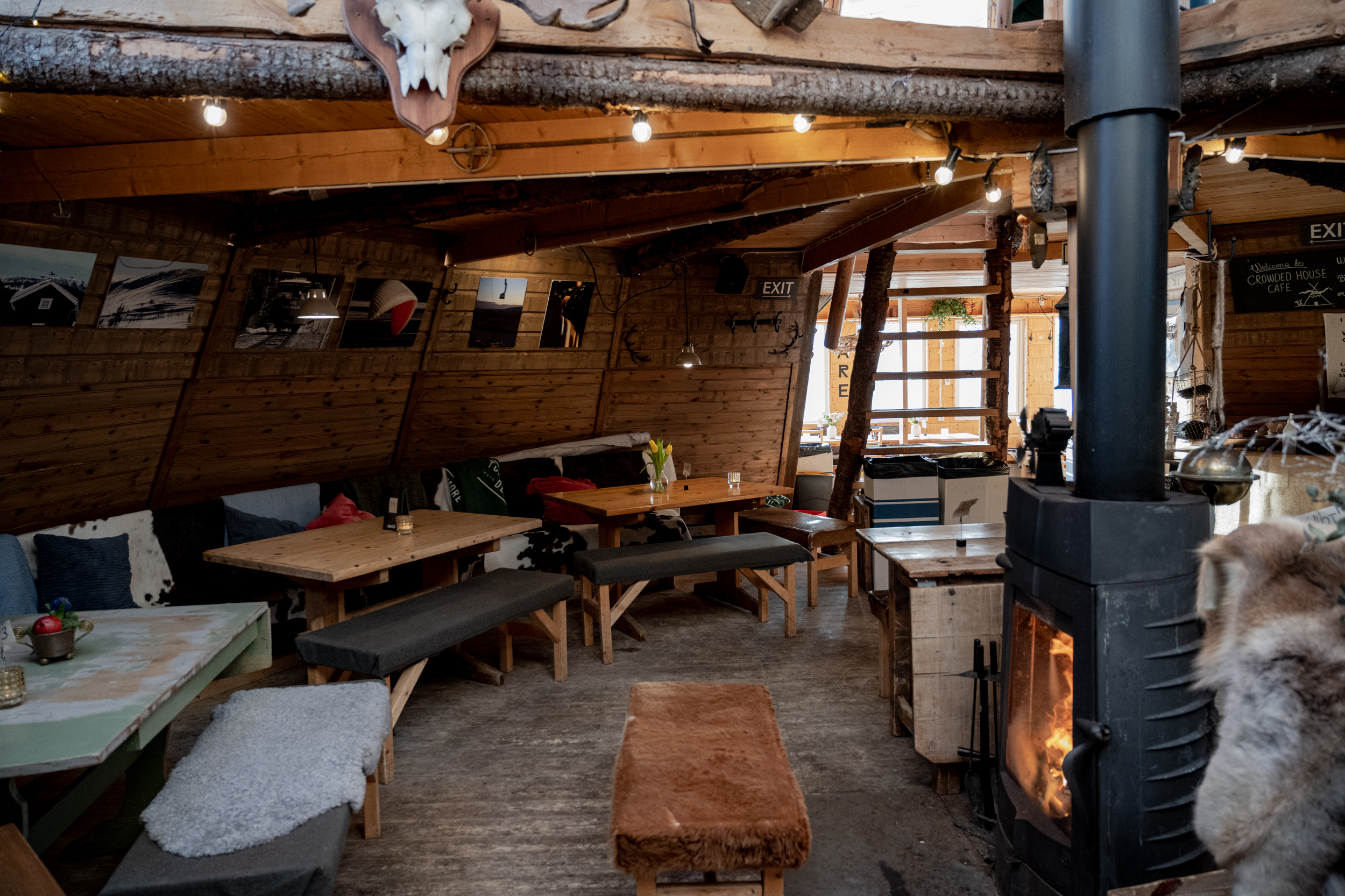 Rustik fjällstuga interiör med mysig kamin, träväggar och sittplatser