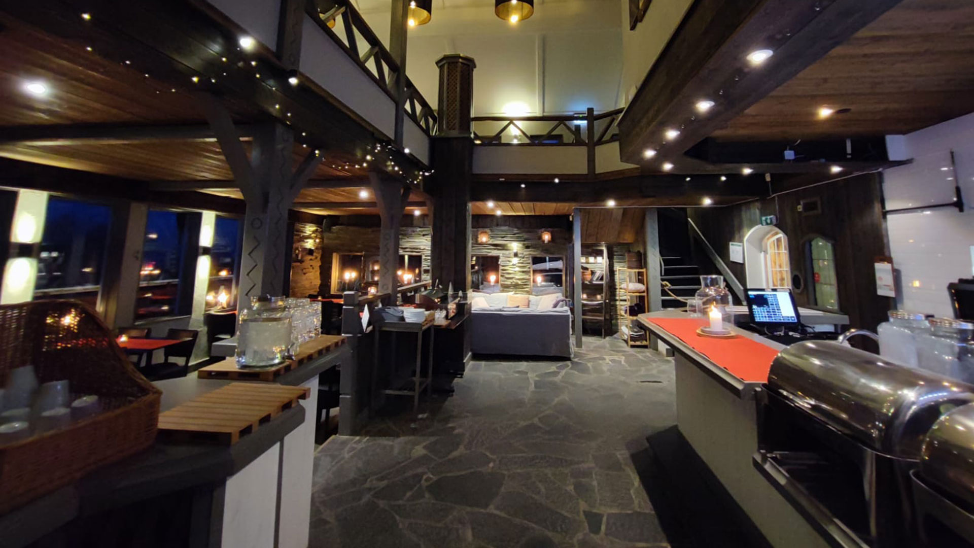 Restauranginteriör med stämningsfull belysning, rustik inredning och öppen planlösning