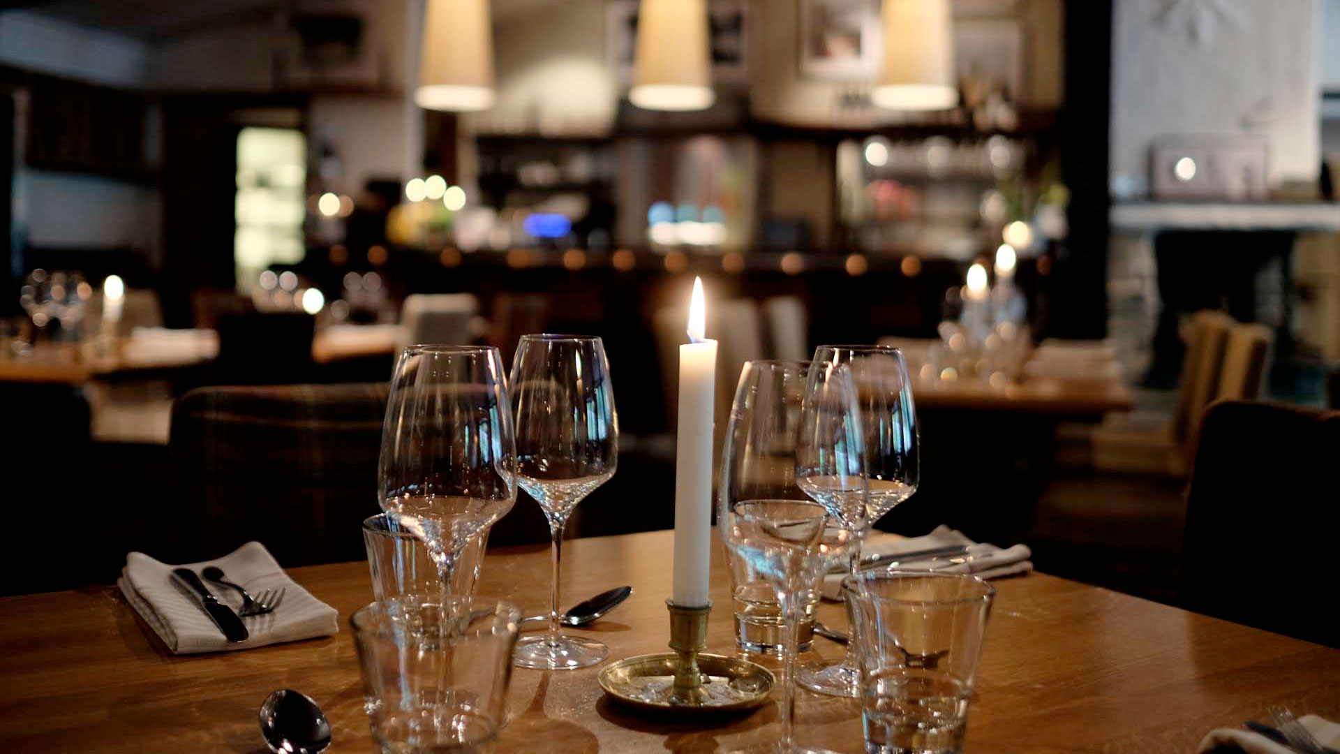 Mysigt dukat restaurangbord med tända ljus och vinglas, inbjudande atmosfär