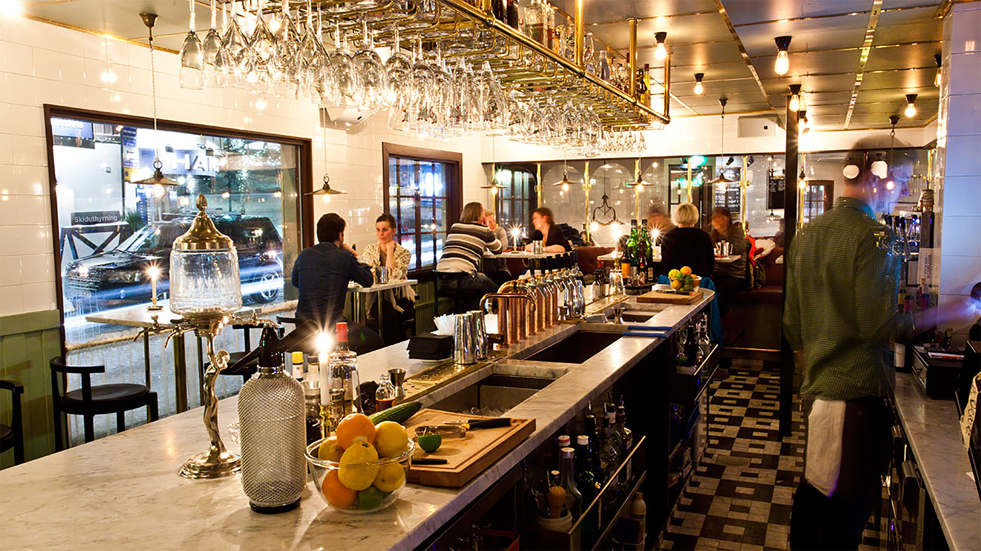 Restauranginteriör med bar och människor som sitter vid bord på en livlig och modern restaurang i Sverige