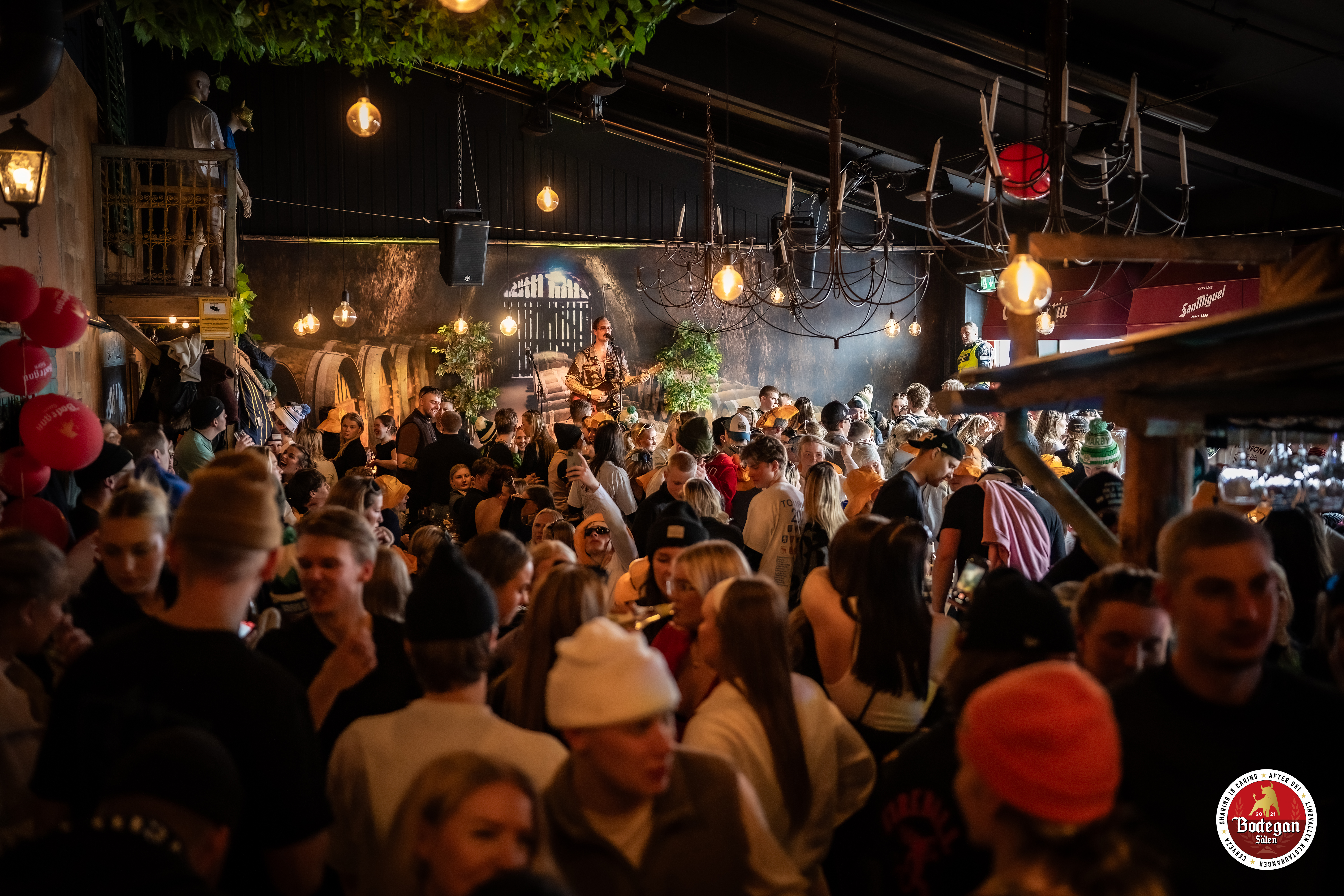 Fullsatt nattklubb med festglada människor och livemusik, med mysig belysning och dekorationer i en atmosfärisk miljö på Bodegan Sälen