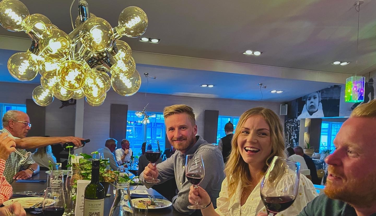 Människor som njuter av vin och god stämning på en livlig restaurang