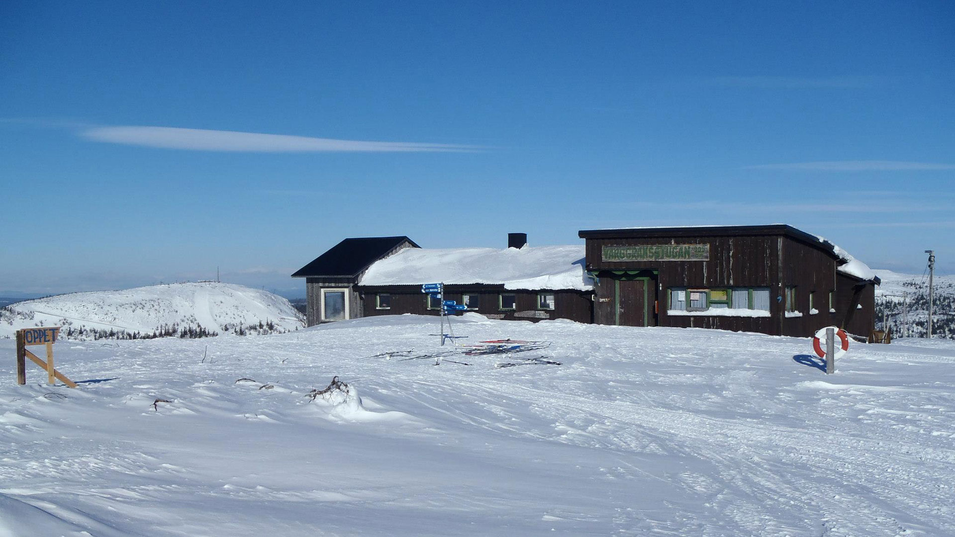 Snötäckt berglandskap med en fjällstuga och klar blå himmel i Sverige