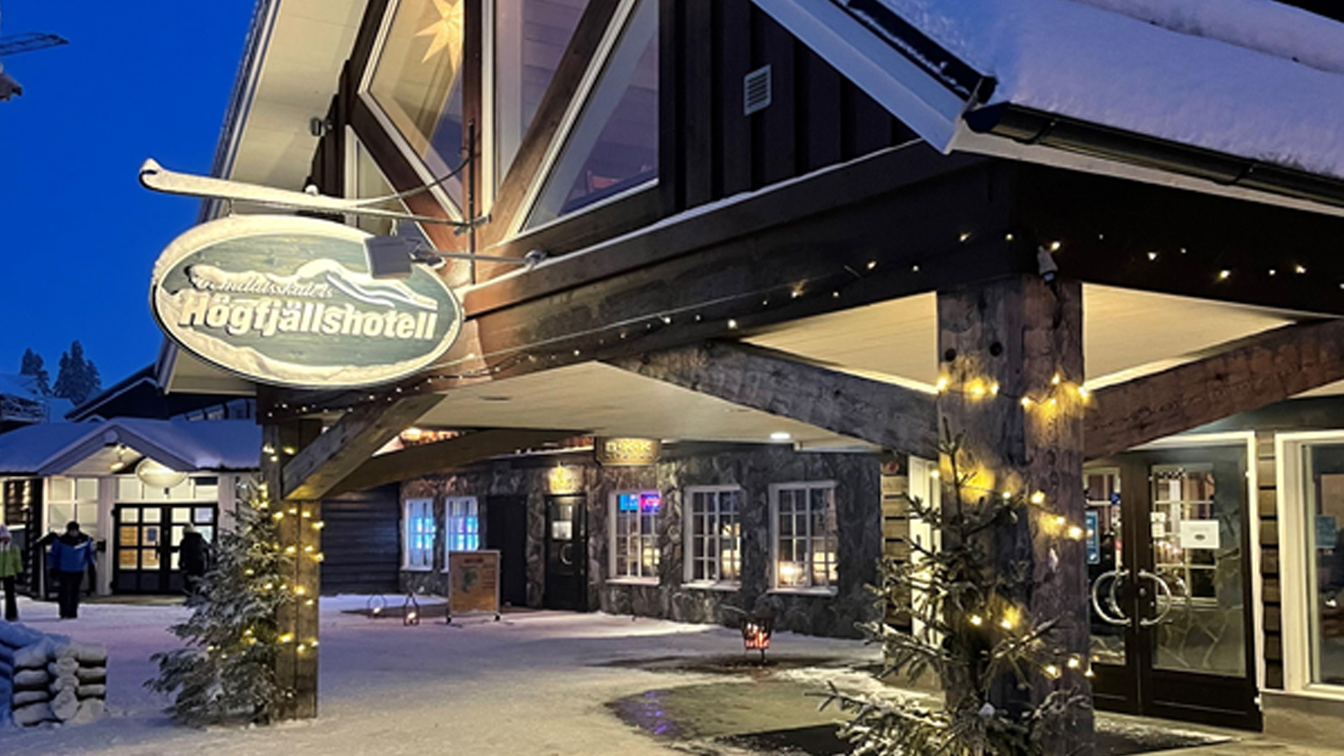 Exteriör av ett fjällhotell i vinterskrud med snö och belysning