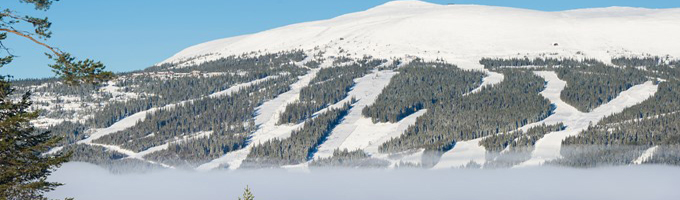 Schneebedeckte Berge mit Skipisten unter einem klarblauen Himmel