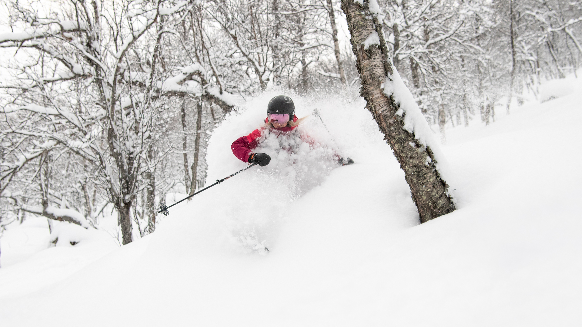 Person åker skidor genom djup snö i en snöig skog