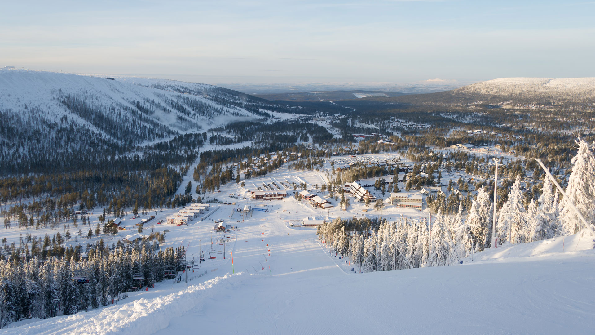 Vintrig utsikt över skidort i Sälenfjällen, Sverige, med snöklädda berg och skidbackar i bakgrunden