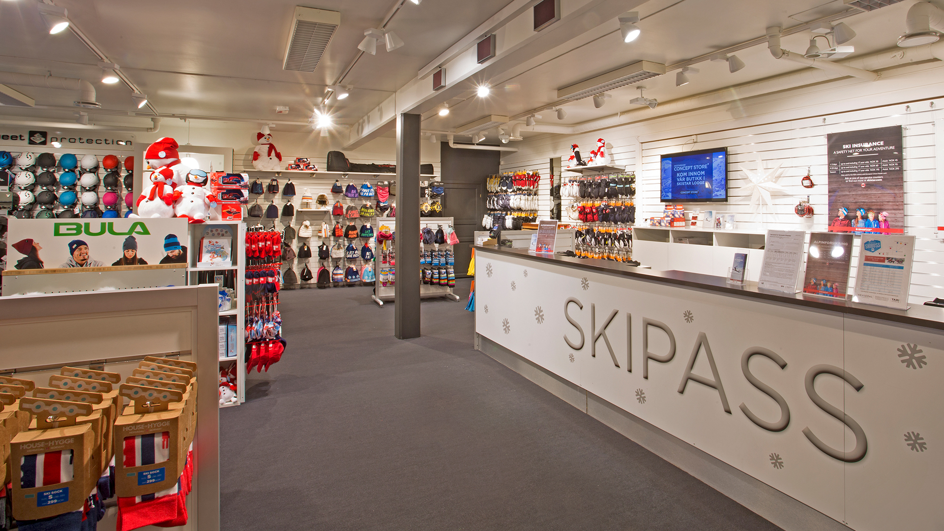 Modern skidshop med skipass-disk, hjälmar, skidhandskar och vinterkläder på display