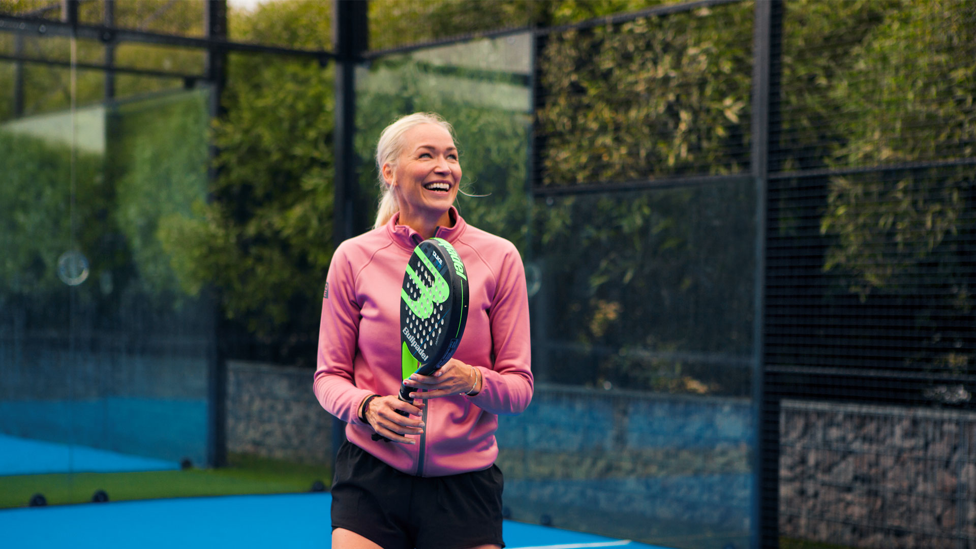 En kvinna som spelar padel i fjällen.