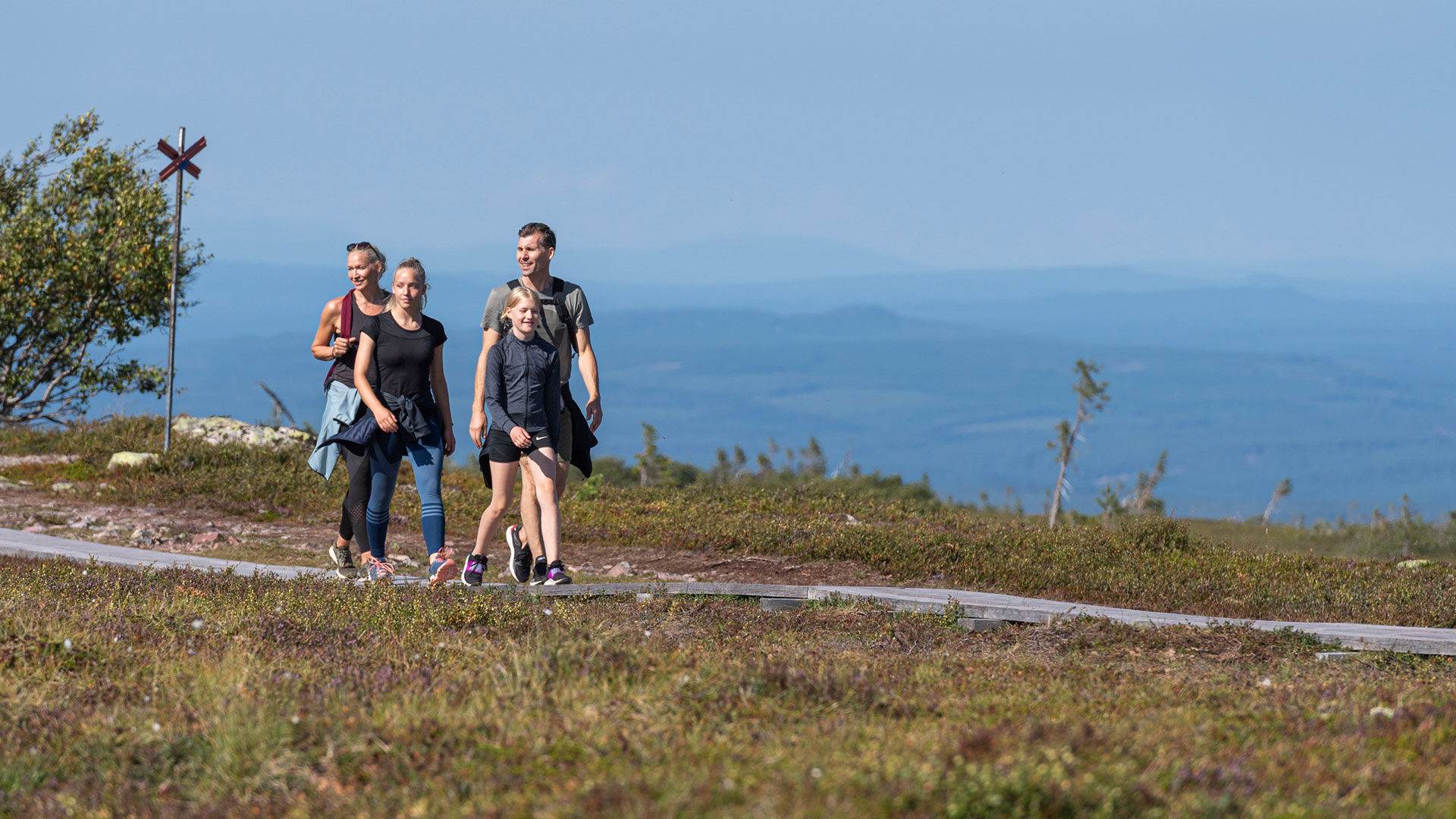En familjs som bokat vandringspaket och som vandrar på fjället.