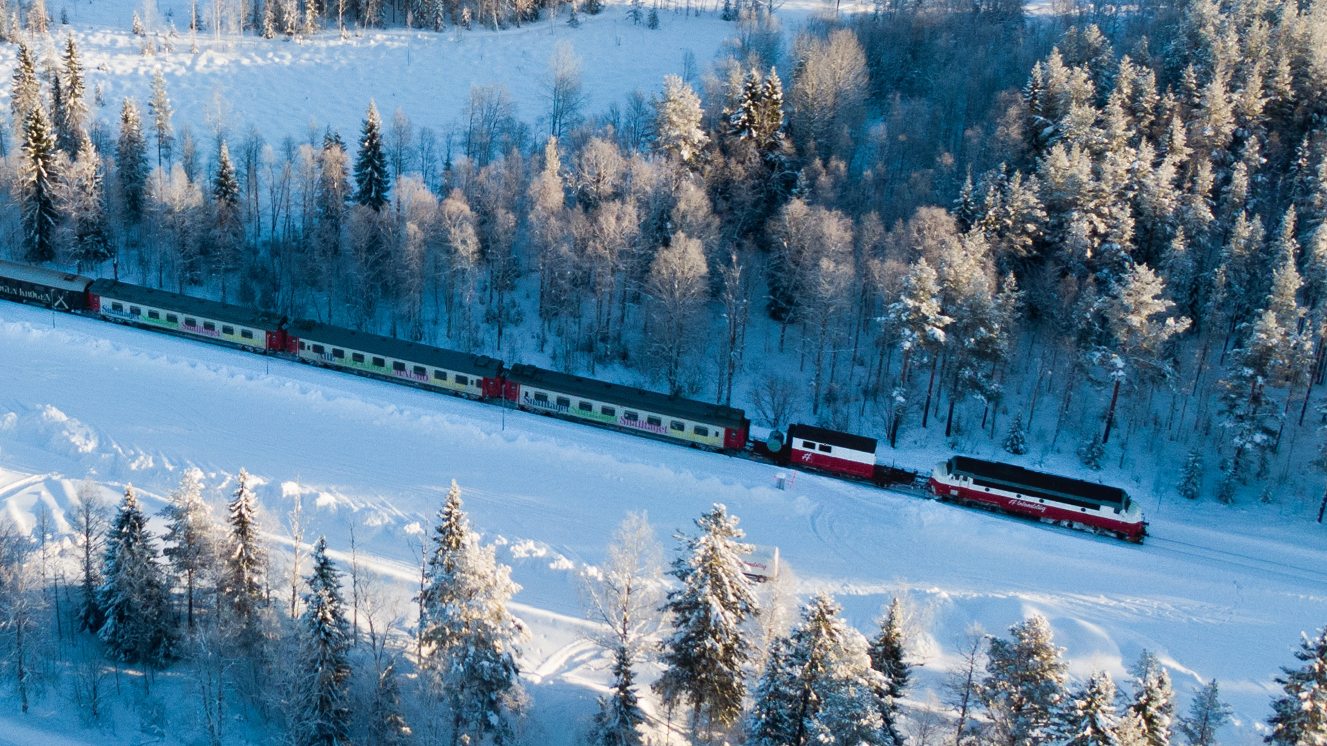 Tåg genom snötäckt skogslandskap i Sverige under vintern